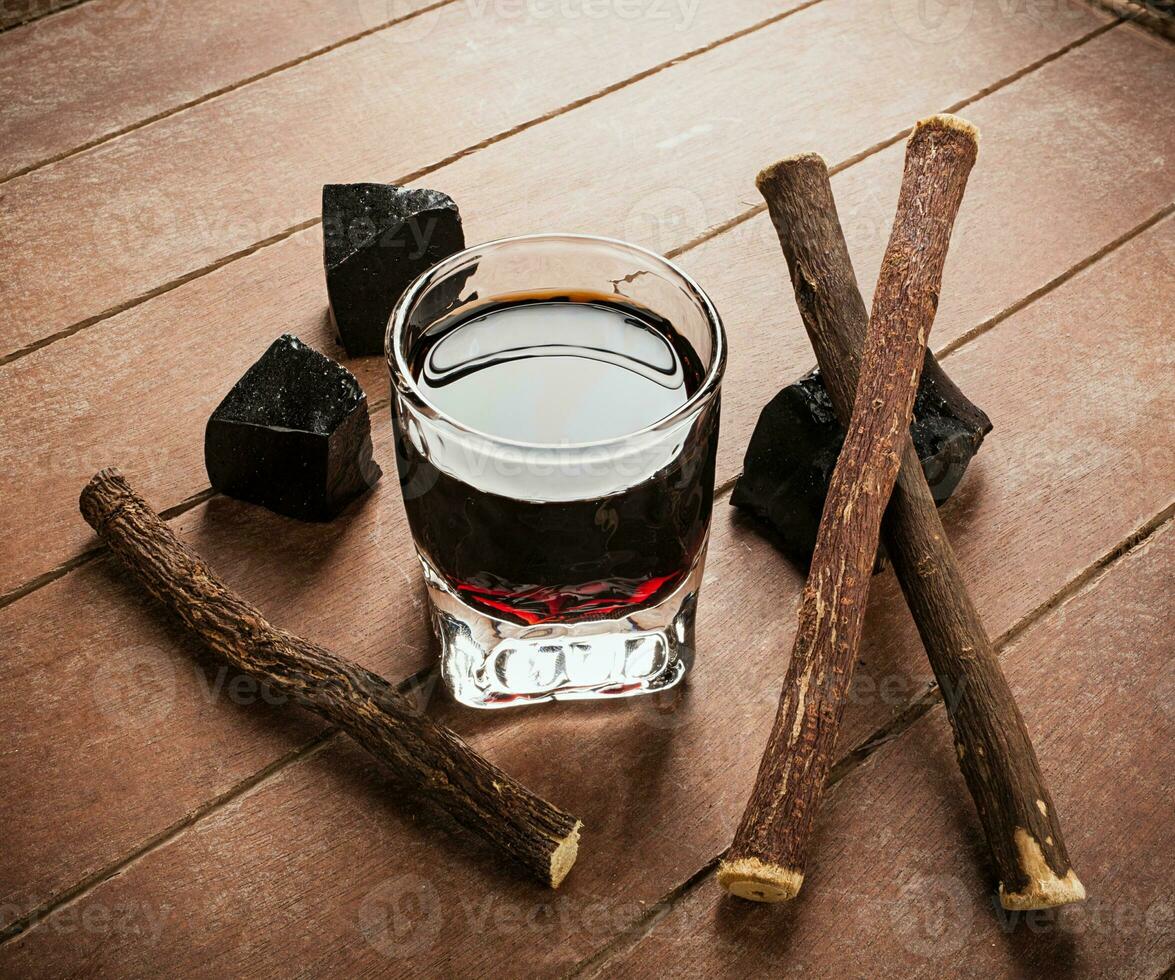 Licorice liqueur with pure blocks and roots. photo