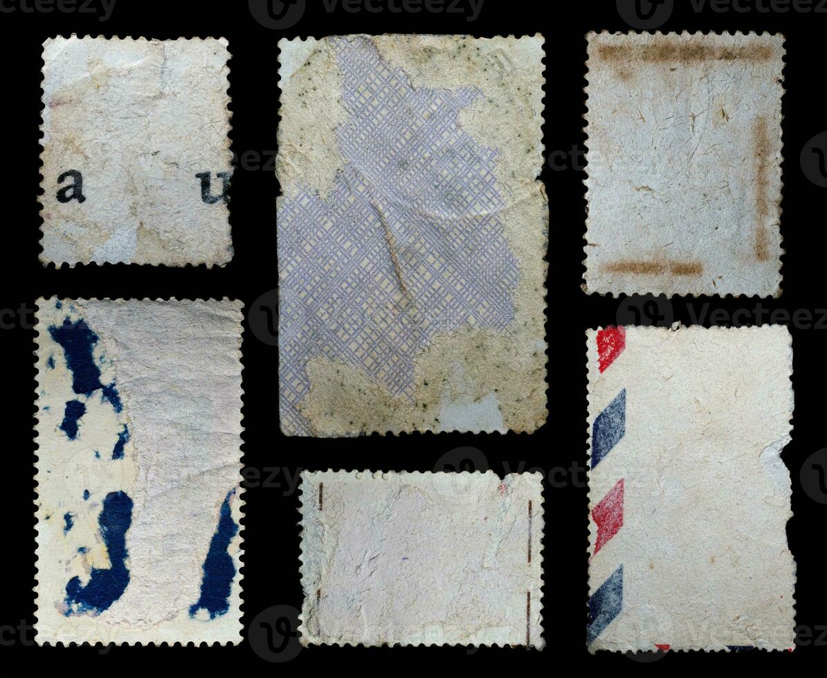 collection of blank vintage postage stamps with different size and texture variation isolated on black background. back side photo