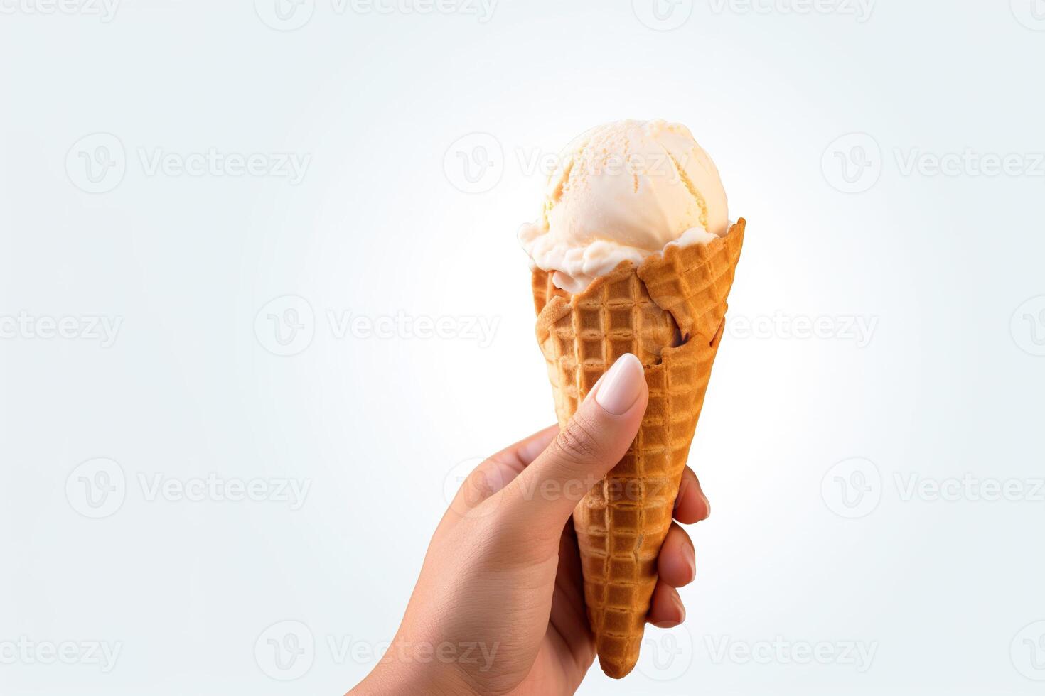 Hand holding delicious vanilla ice cream in a crispy waffle cone with copy space. photo