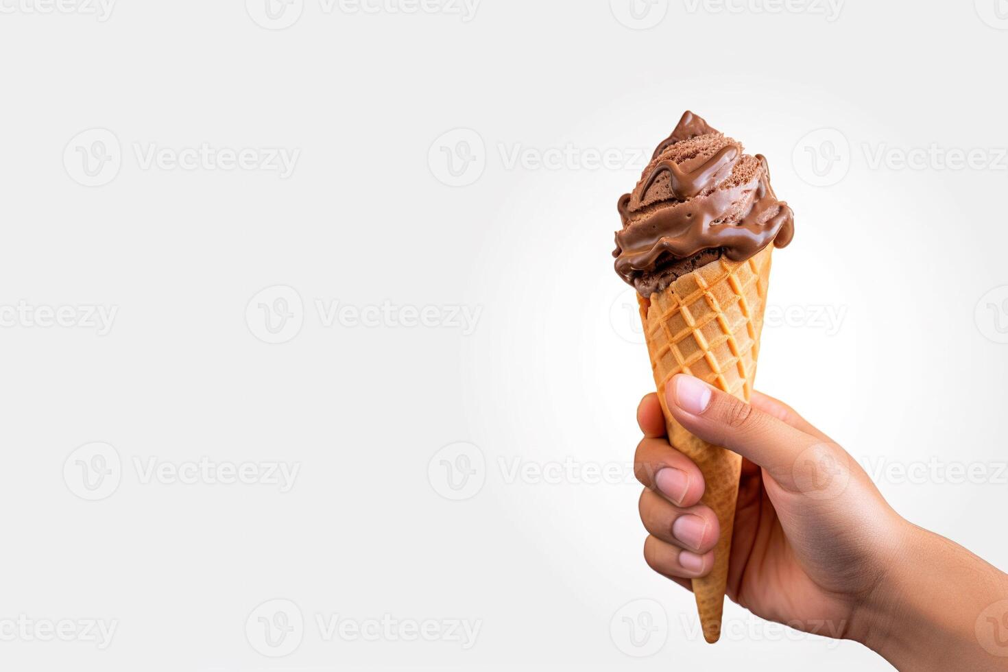 Hand holding delicious chocolate ice cream in a crispy waffle cone with copy space. photo