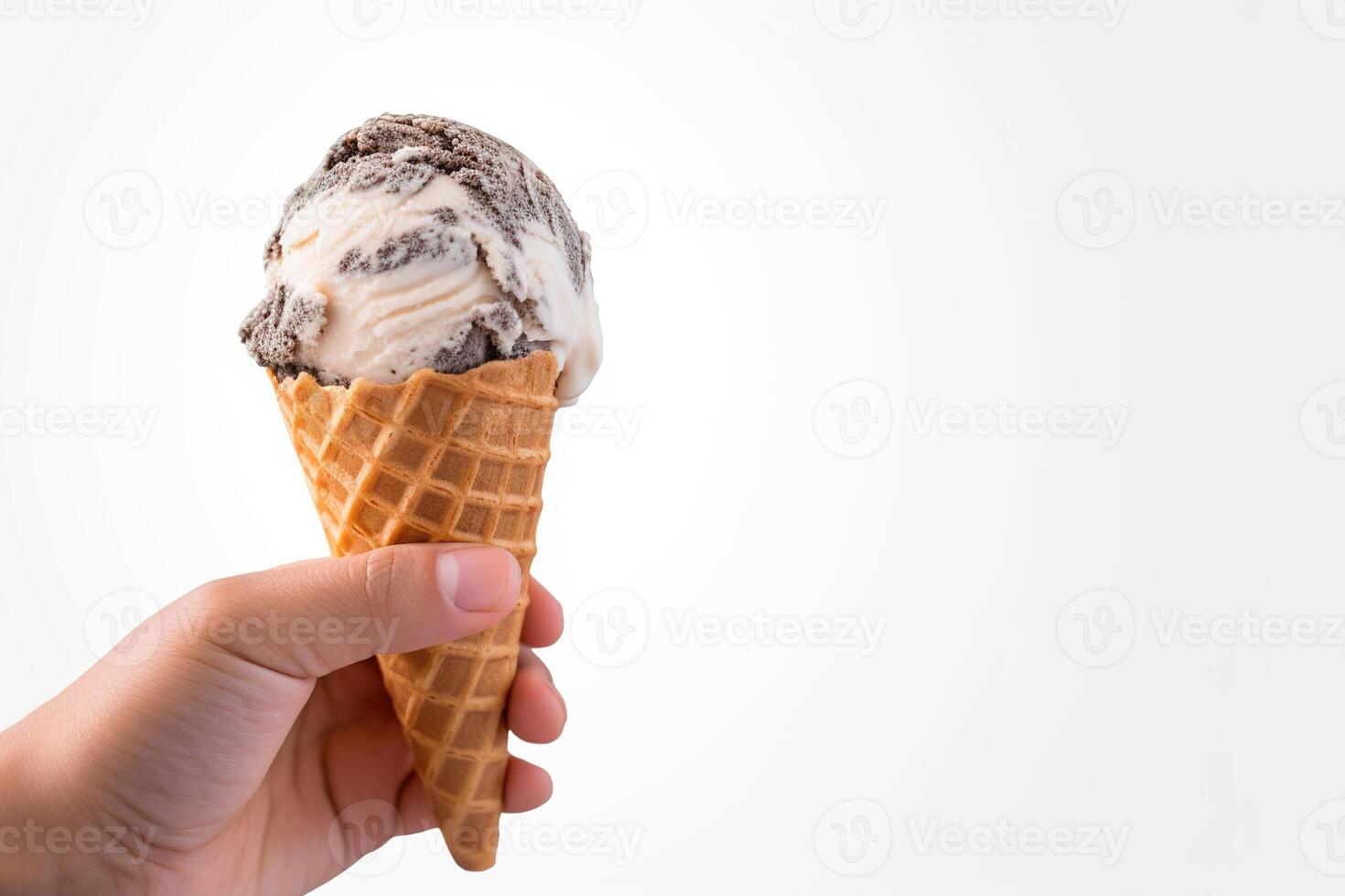 Hand holding delicious cookies and cream ice cream in a crispy waffle cone with copy space. photo