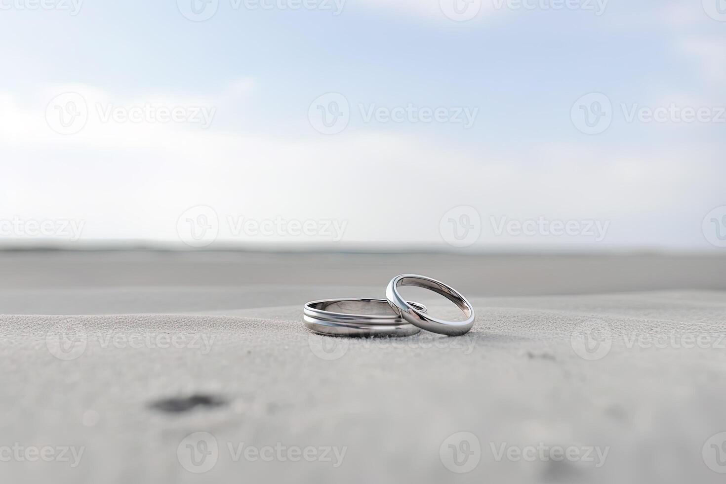 Two wedding rings in the sand on the background of a beach and sea. photo