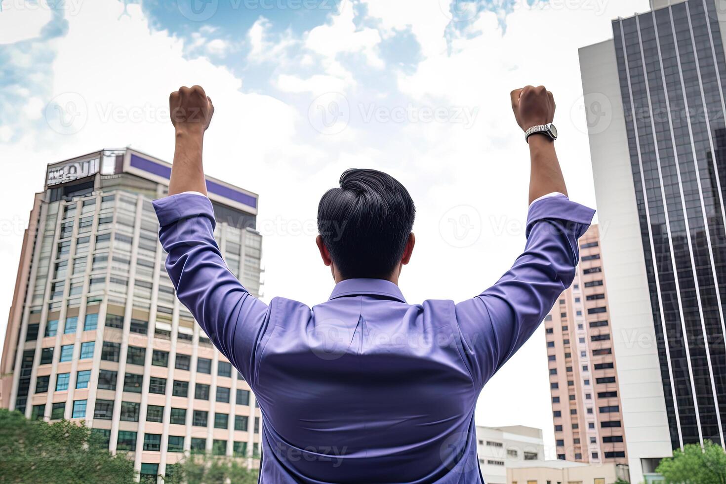 Successful businessman raising hand and expressing positivity while standing against skyscrapers background. photo