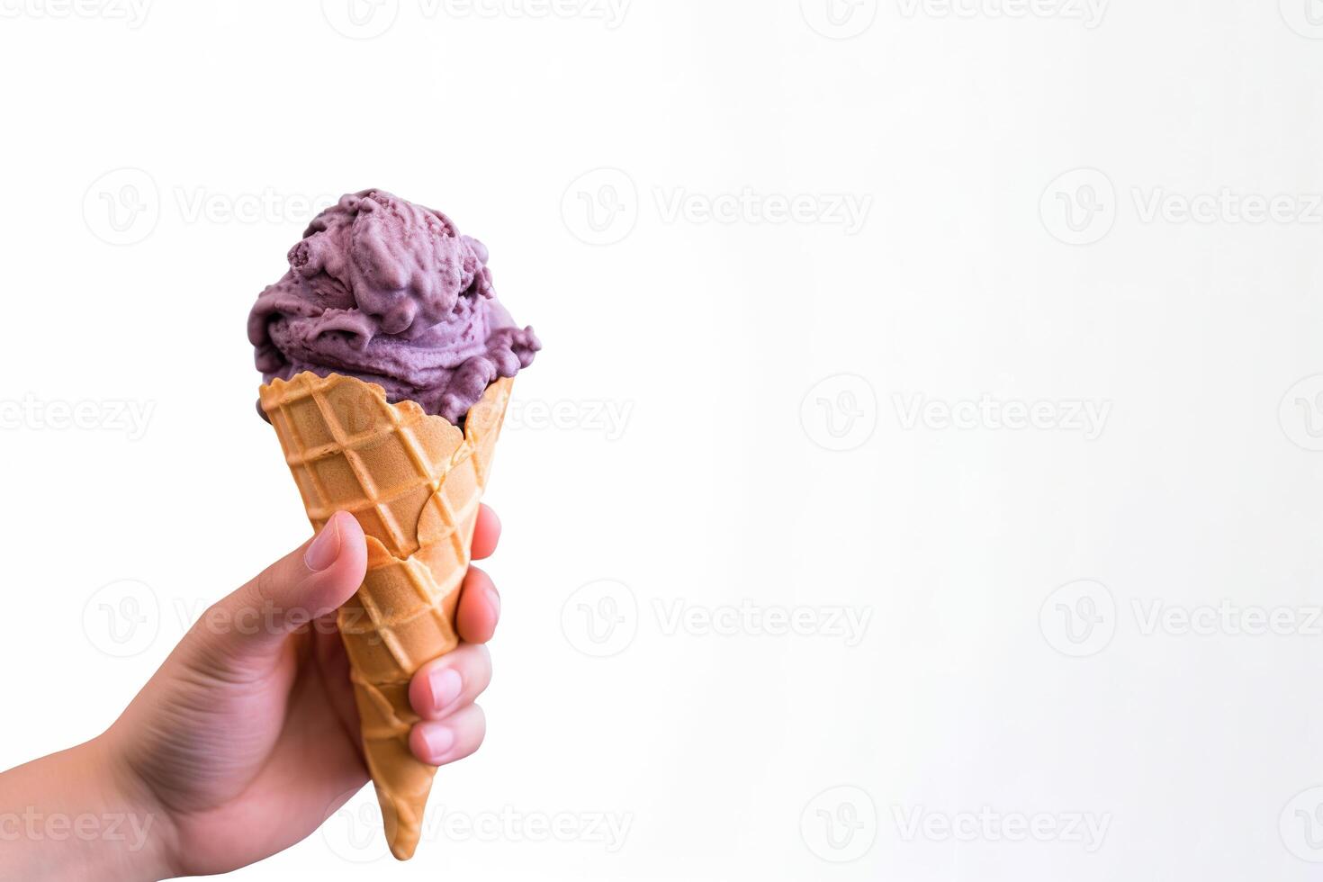 Hand holding delicious blueberry ice cream in a crispy waffle cone with copy space. photo