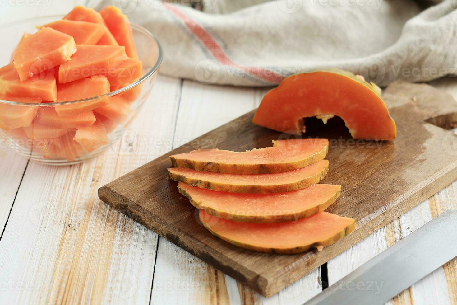 Thin Slice Papaya on Wooden Table, Cubed Papaya on Bowl. photo
