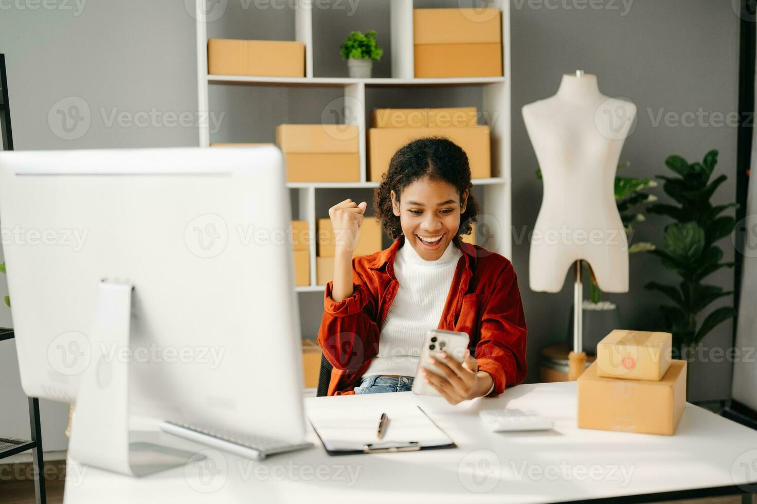 Young business owner African woman prepare parcel box and standing check online orders for deliver to customer on tablet, laptop Shopping Online concept. in office photo