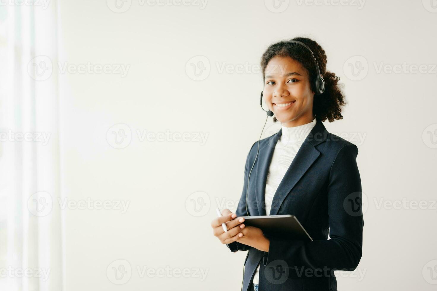 Serious call center operator in wireless headset talking with customer, woman in headphones with microphone consulting client on phone in customer support service in business center photo