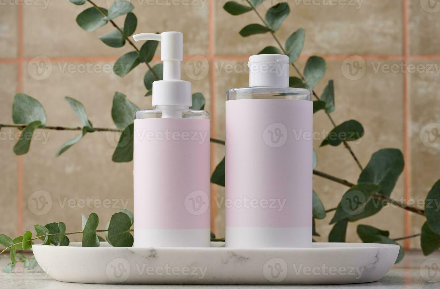 dos botellas para productos cosméticos con un rosado papel etiqueta en un blanco antecedentes. botella para tónico, gel foto