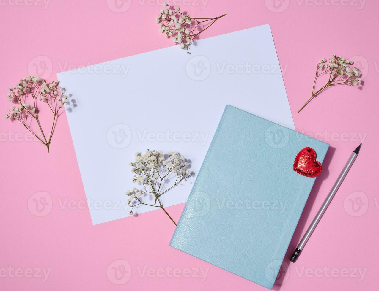 Notebook, wooden pencil on pink background, top view photo