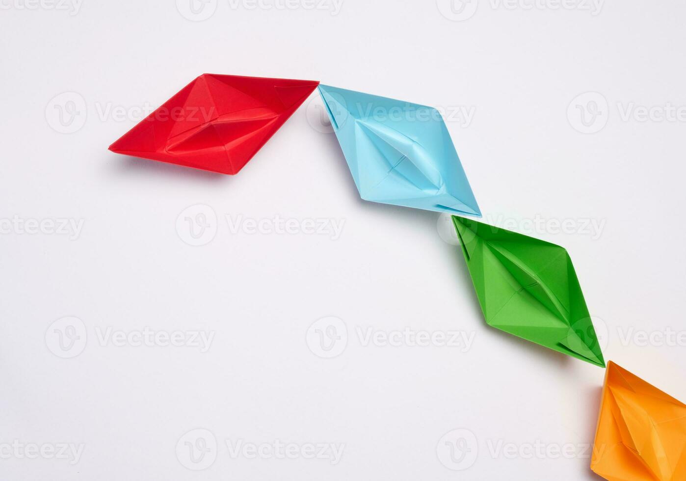 Group of paper boats on a white background.Concept of a strong leader in a team, manipulation of the masses, following new perspectives photo