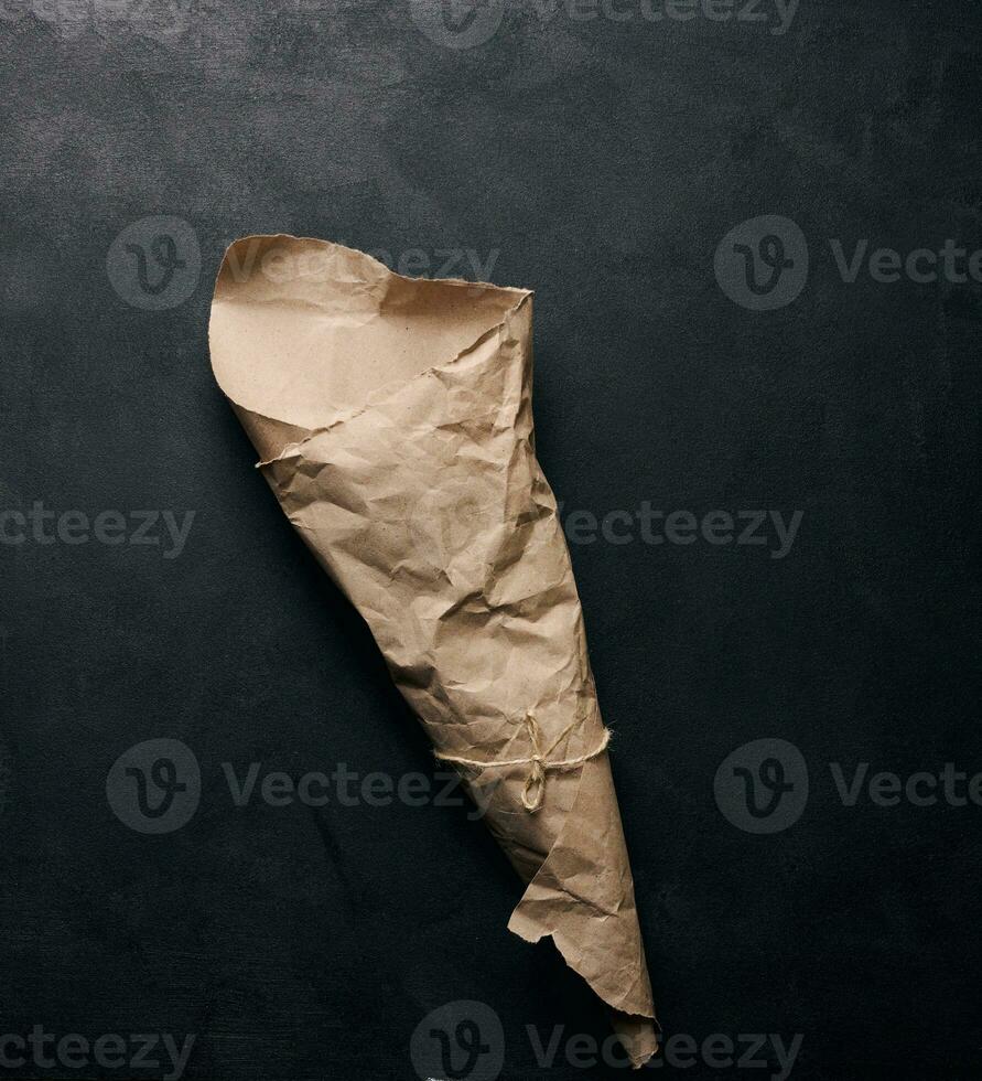 Empty bag of brown craft paper on a black background photo