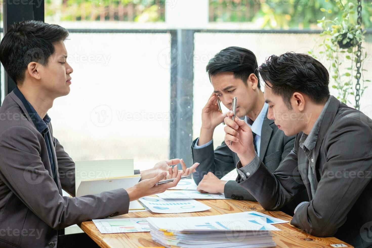 Asian business team consists of marketing staff. accountant and financial officer Help each other analyze company profits using graph paper, and corporate pens. photo