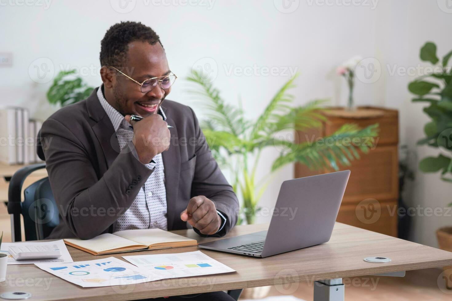 africano americano empresario analizando ordenador portátil grafico papeleo en oficina participación documentos preparando portafolio análisis reporte negro masculino analista haciendo papeleo en el lugar de trabajo utilizando el computadora. foto