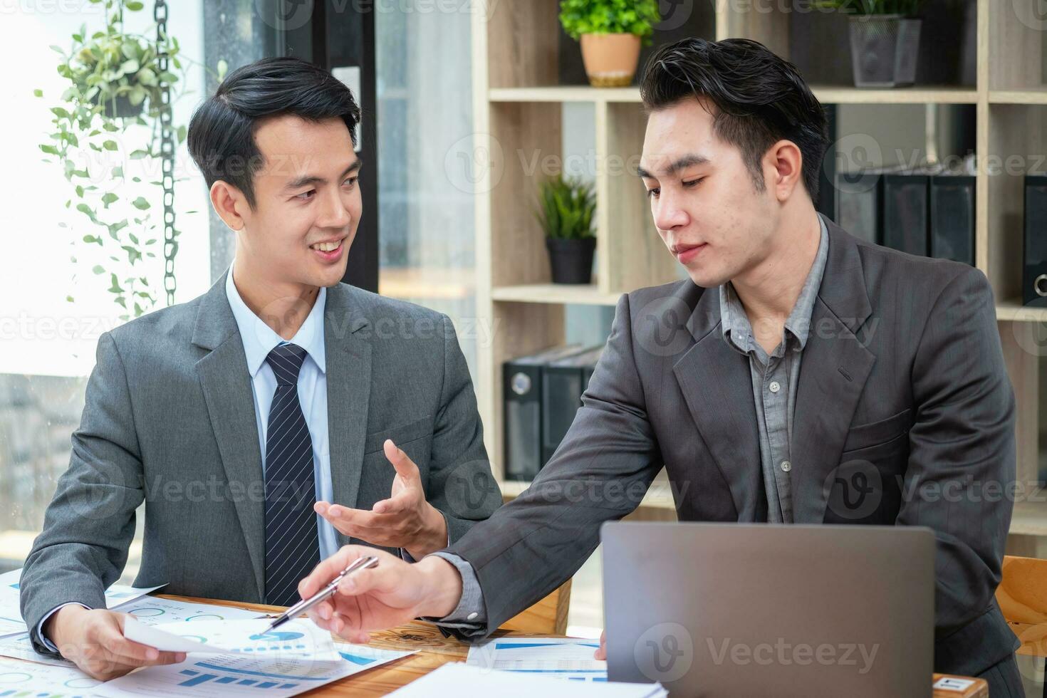 Asian business team consists of marketing staff. accountant and financial officer Help each other analyze company profits using tablets. calculator Laptop computers, graph paper, and corporate pens. photo