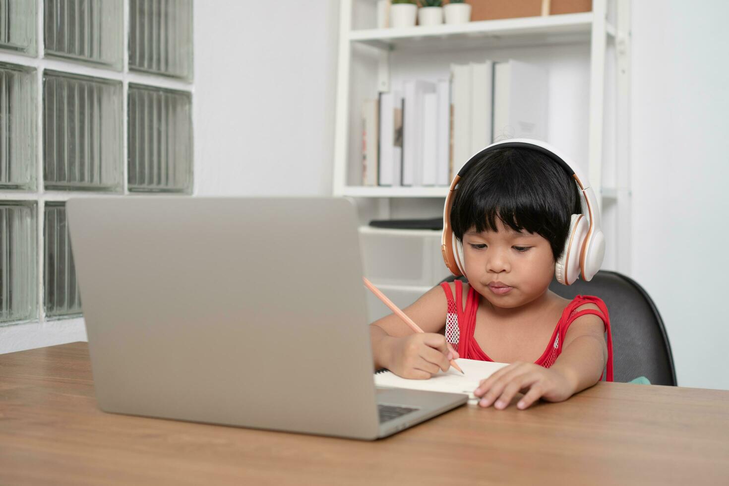 Happy Asian girl student online learning class from a computer with a teacher, online education is a technology for social distance in a new normal lifestyle, Concept of home school and tutor photo