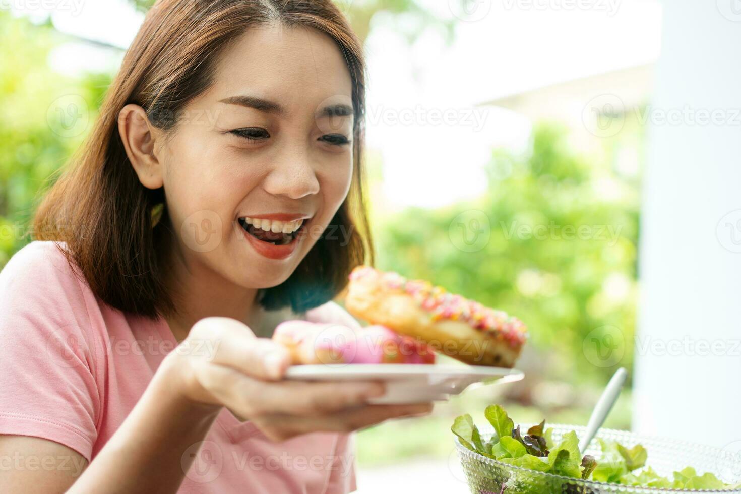 el hermosa asiático sano medio Envejecido mujer es contento a comer rosquillas porque tener no comido para un largo hora porque eso es esperando para salud. concepto de salud cuidado y nutritivo comida foto