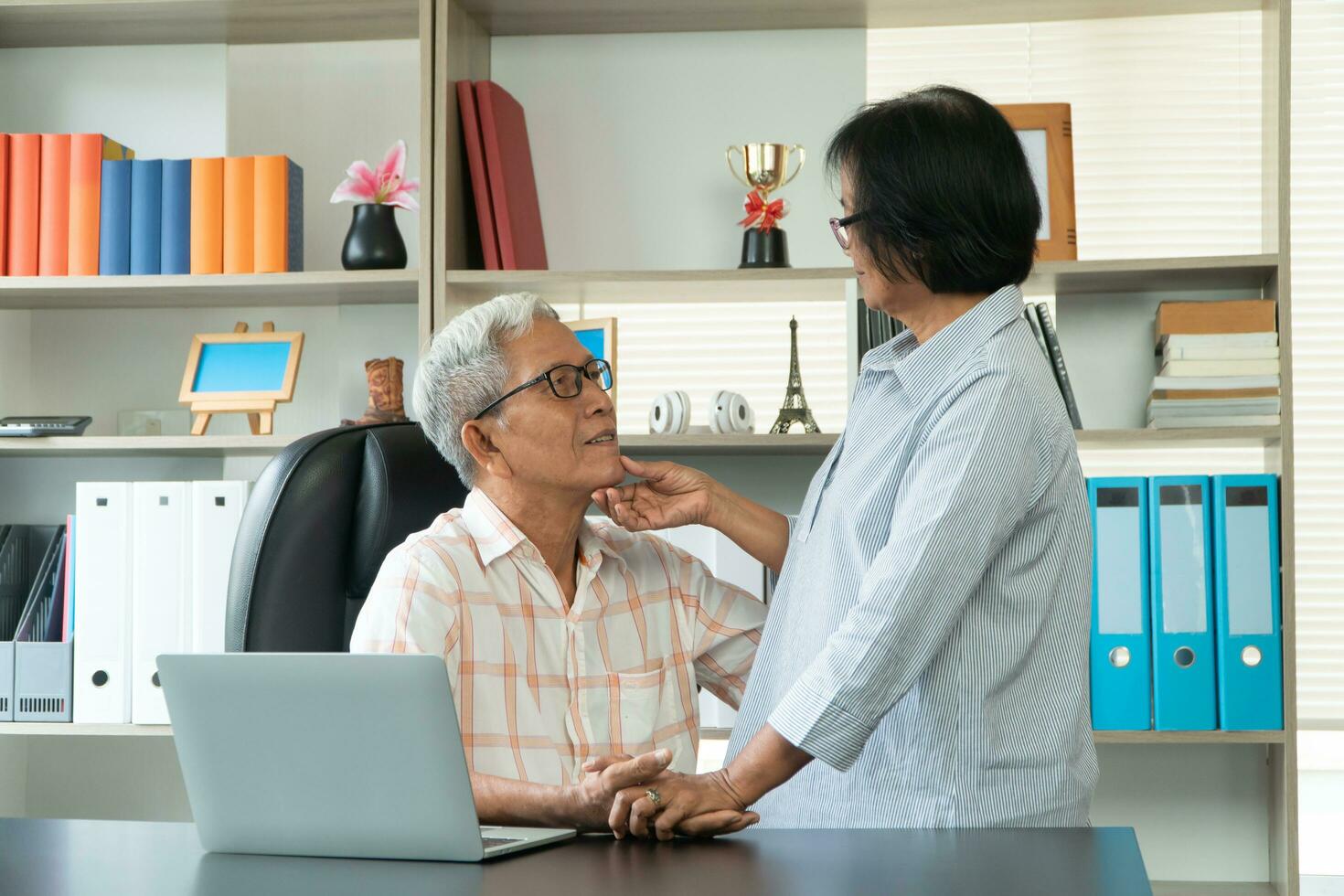 Happy senior Asian couple using a laptop at home for find new tourist attractions together. Happy retirement with planning, saving, pension And the good capital uncle of the elderly photo