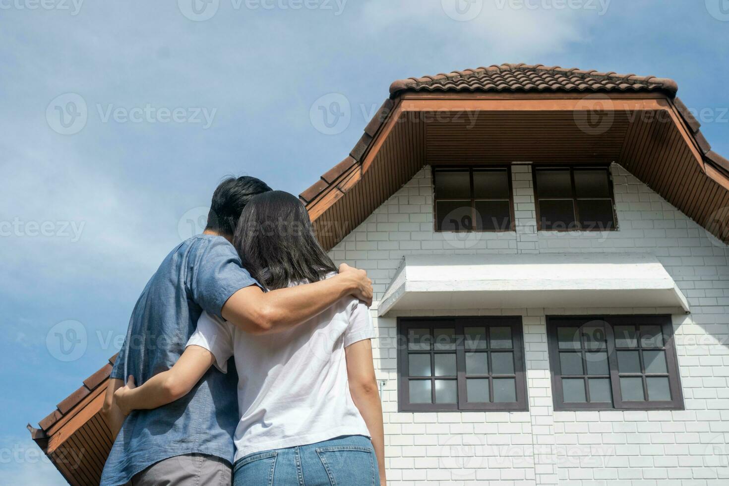 contento Pareja en frente de el nuevo hogar en Moviente en día, y comienzo un nuevo vida familia. concepto de dueño de casa y reubicación foto