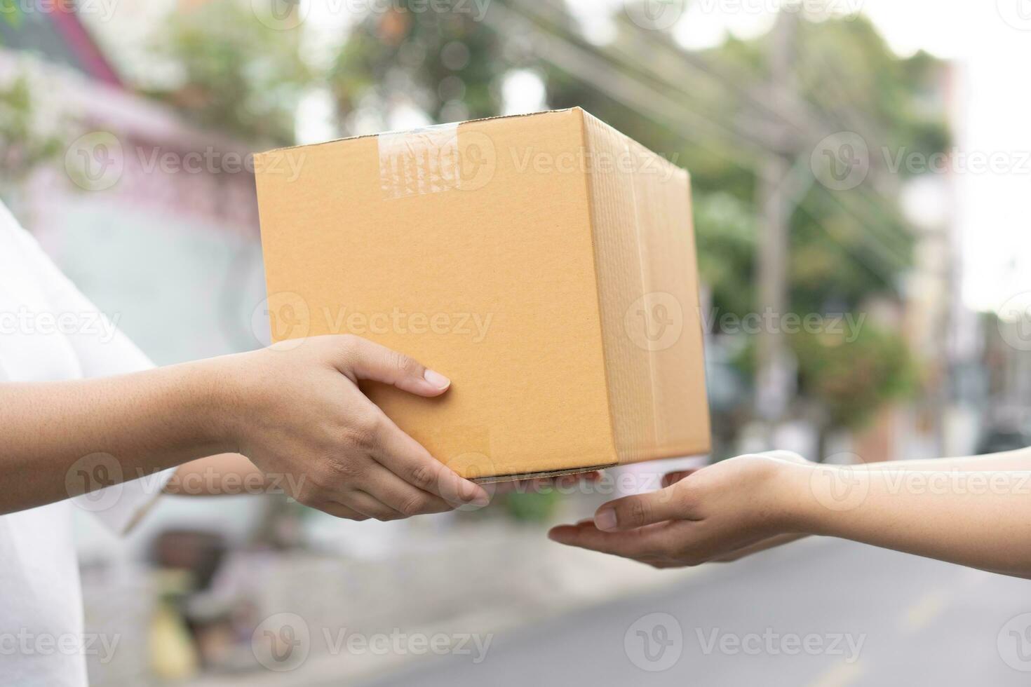 Postal service sending paper cardboard box to customer in front of a house outdoor. Shipping service arrival and send to customer address. photo