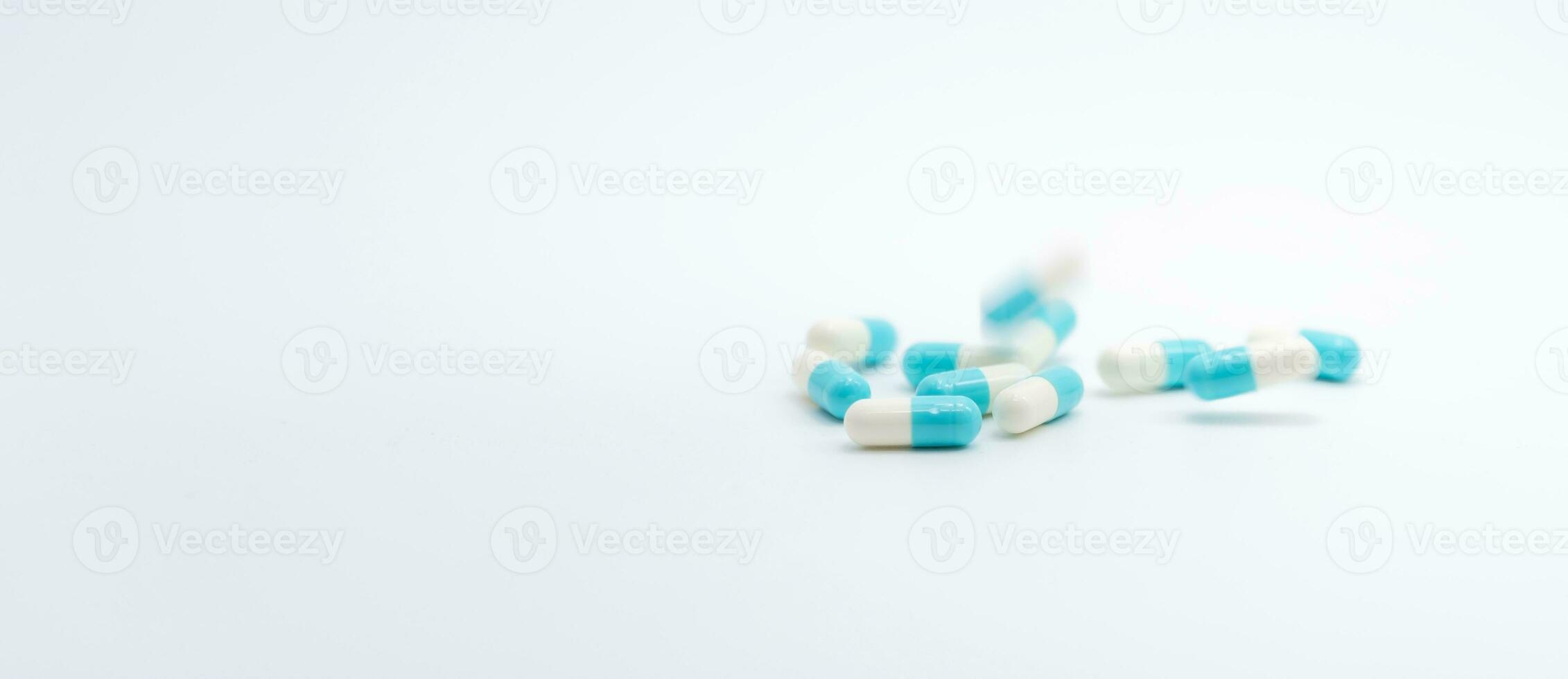 Antibiotic capsules pill falling on white background. Pharmacy banner. Antibiotic drug resistance. Prescription medicine. Medical healthcare concept. Pharmaceutical industry. Blue-white capsule pill. photo