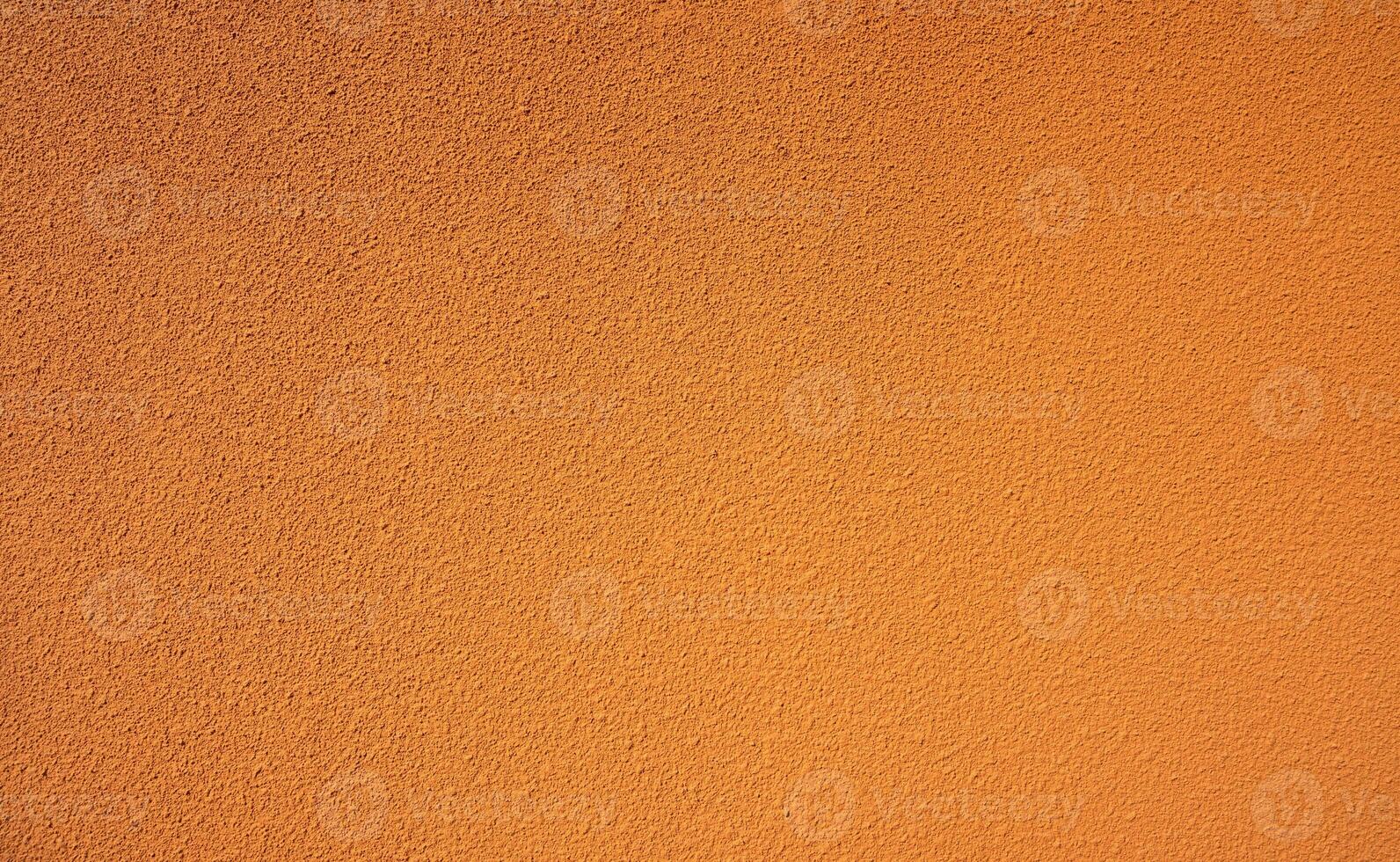 Orange rough concrete wall texture background. Empty orange concrete wall abstract background. Full frame orange cement wall texture background. Blank grain stucco wall. Orange concrete material. photo