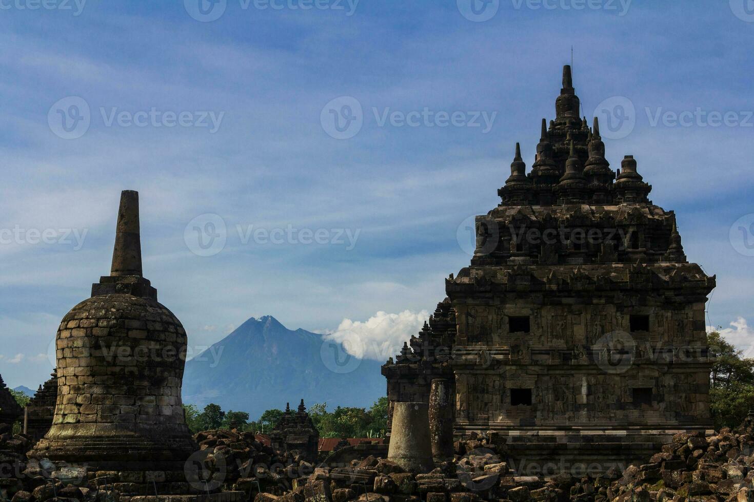 Wide view of Candi Plaosan with Gunung Merapi as the background under bright afternoon blue sky photo