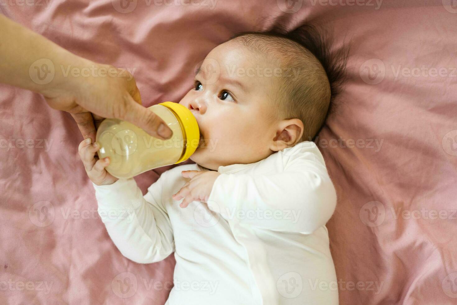 image of a newborn baby lying on a pink bed photo