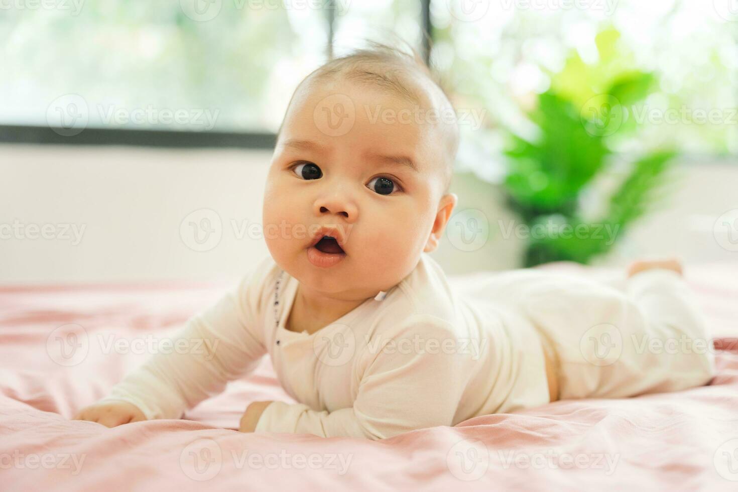 image of a newborn baby lying on a pink bed photo