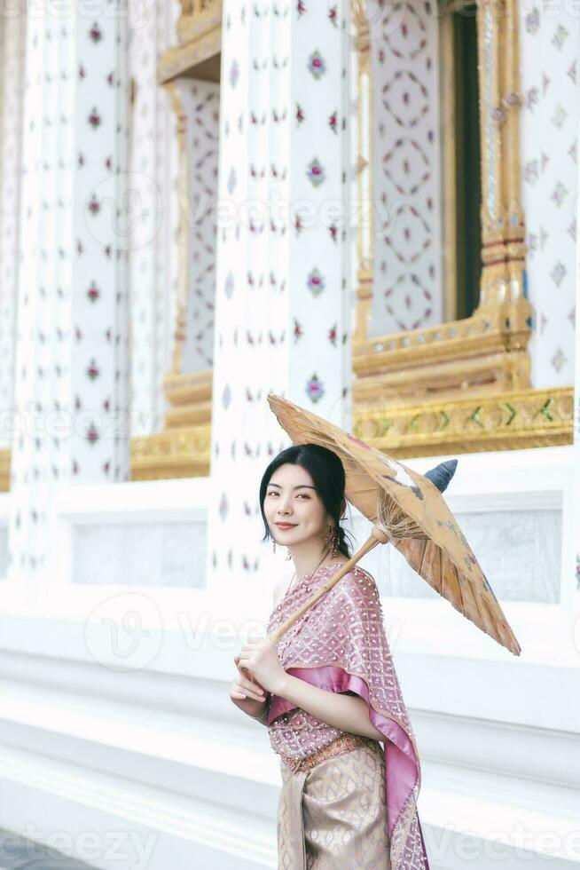 Beautiful Asian girl in Thai traditional costume at temple photo