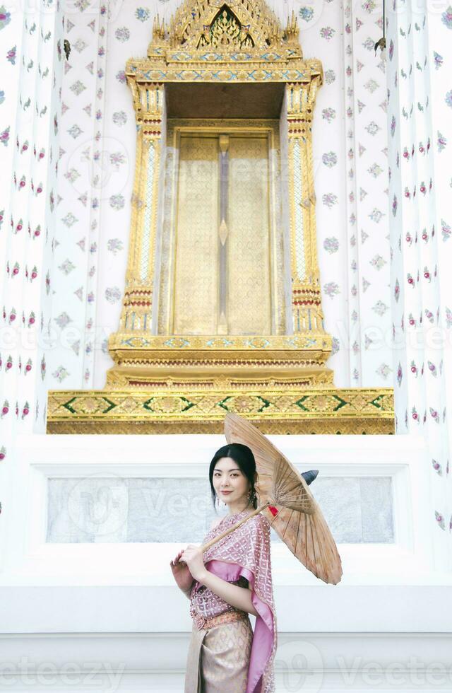 Beautiful Asian girl in Thai traditional costume at temple photo