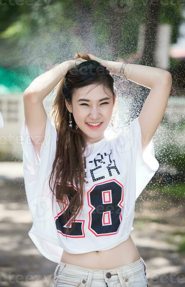 Happy Chinese girl is getting wet and rain photo