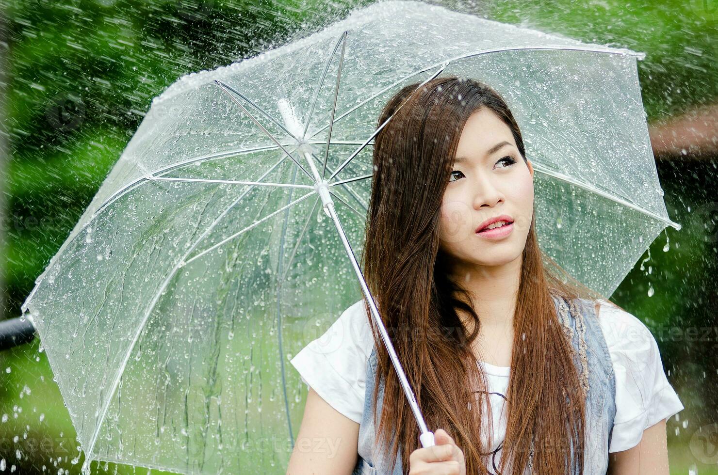 Beautiful girl is standing with umbrella  among a rain 1 photo