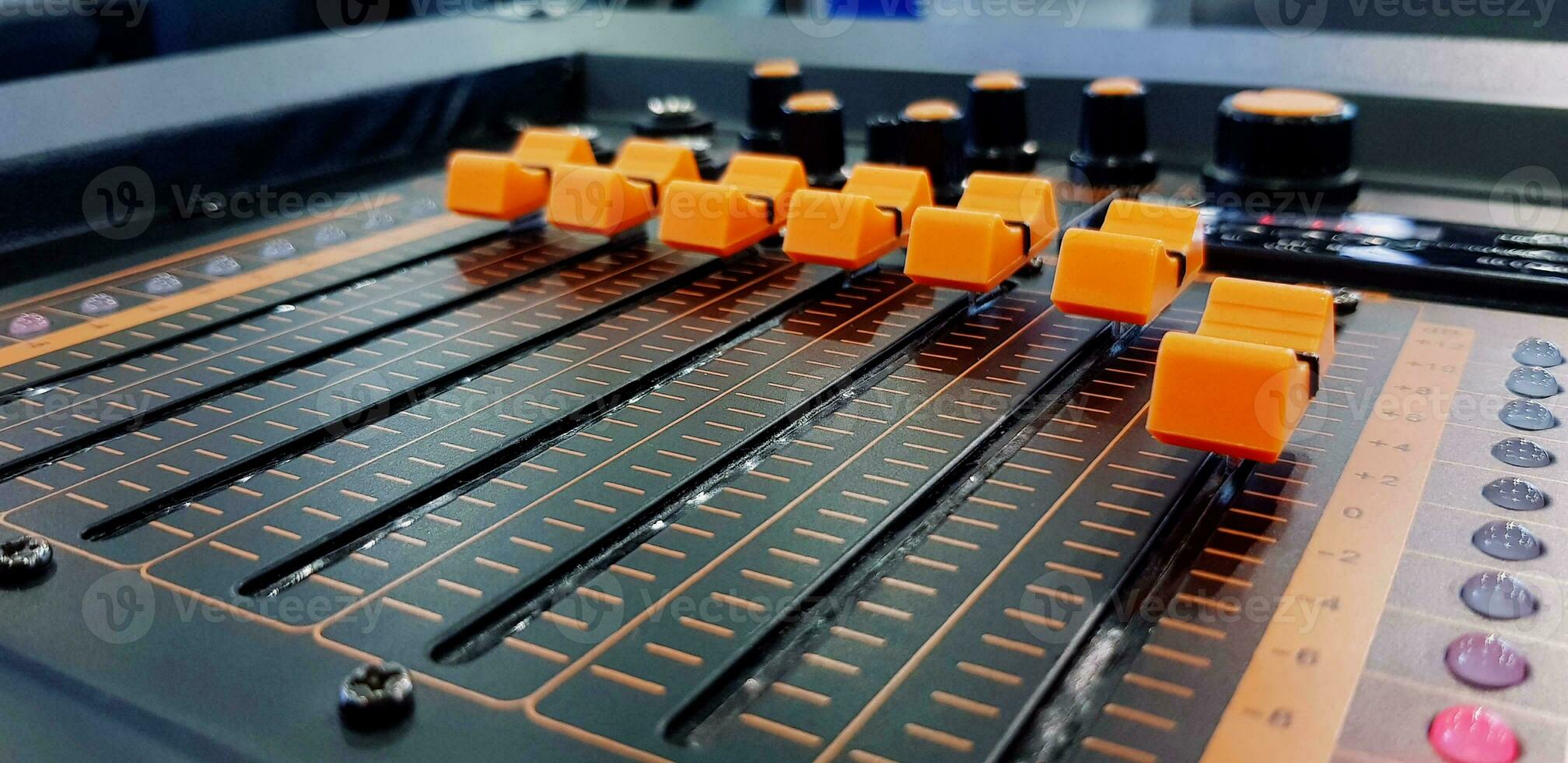 Close up orange button of sound mixer panel equipment for mixing or control audio system with selective focus technique. Technology, Tool and Digital device concept photo