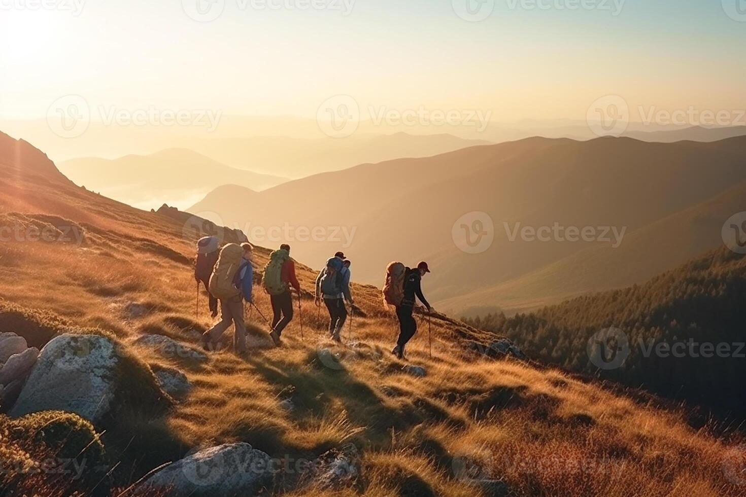 A group of backpackers walking through the mountains at sunset. photo