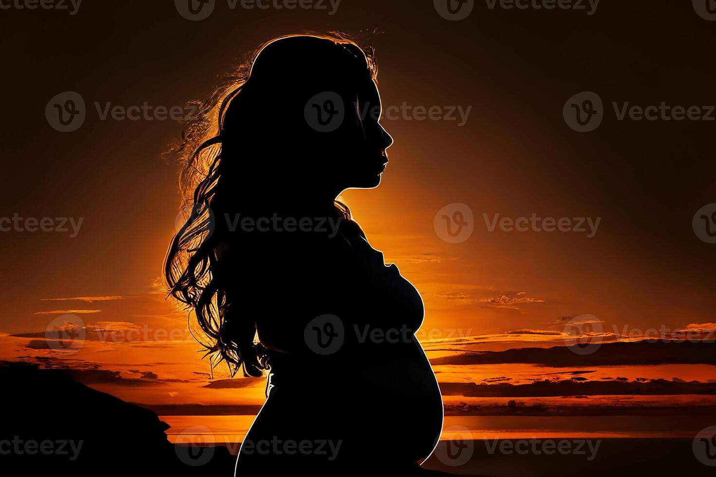 Silhouette of a pregnant woman against the background of the sunset. photo