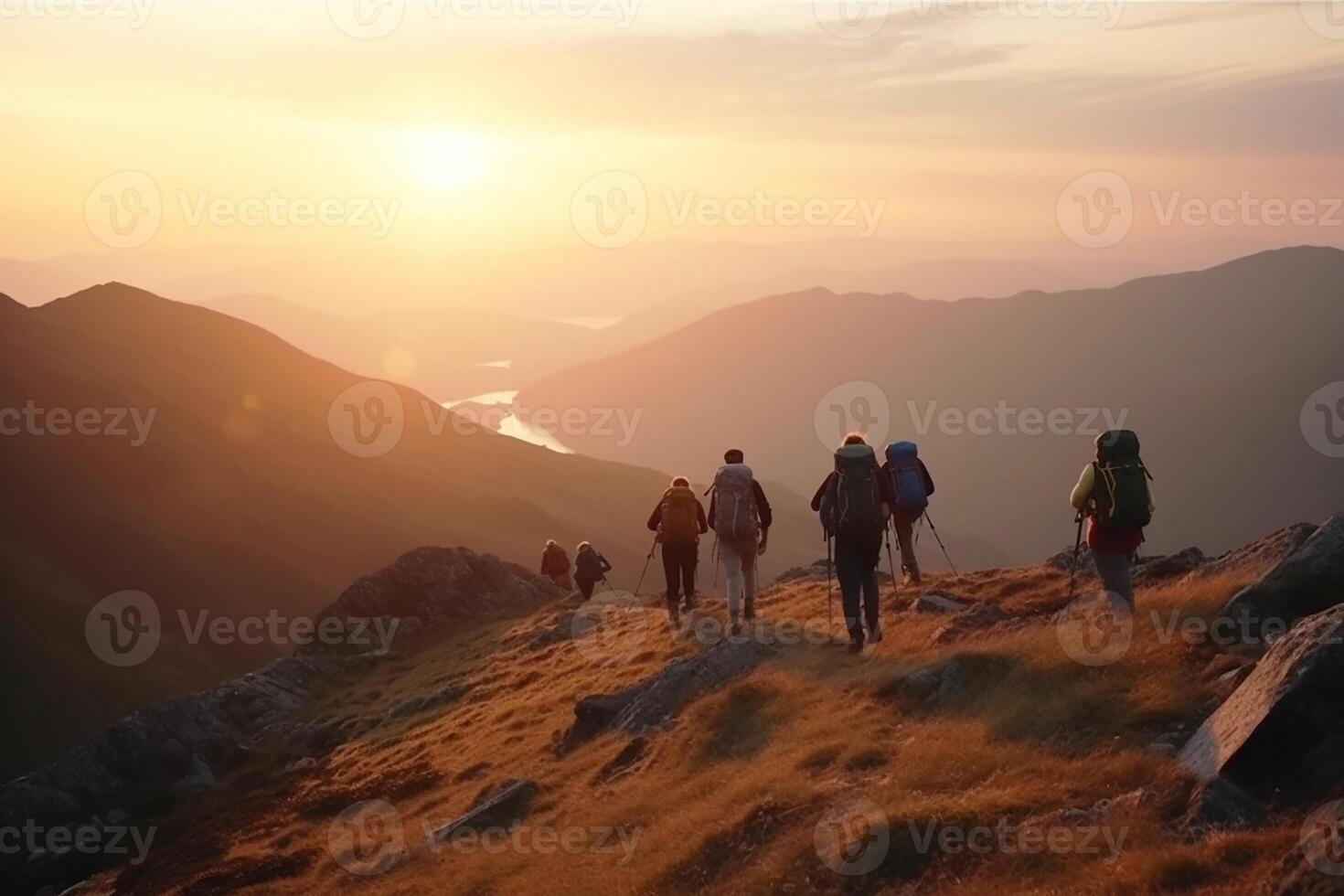 A group of backpackers walking through the mountains at sunset. photo