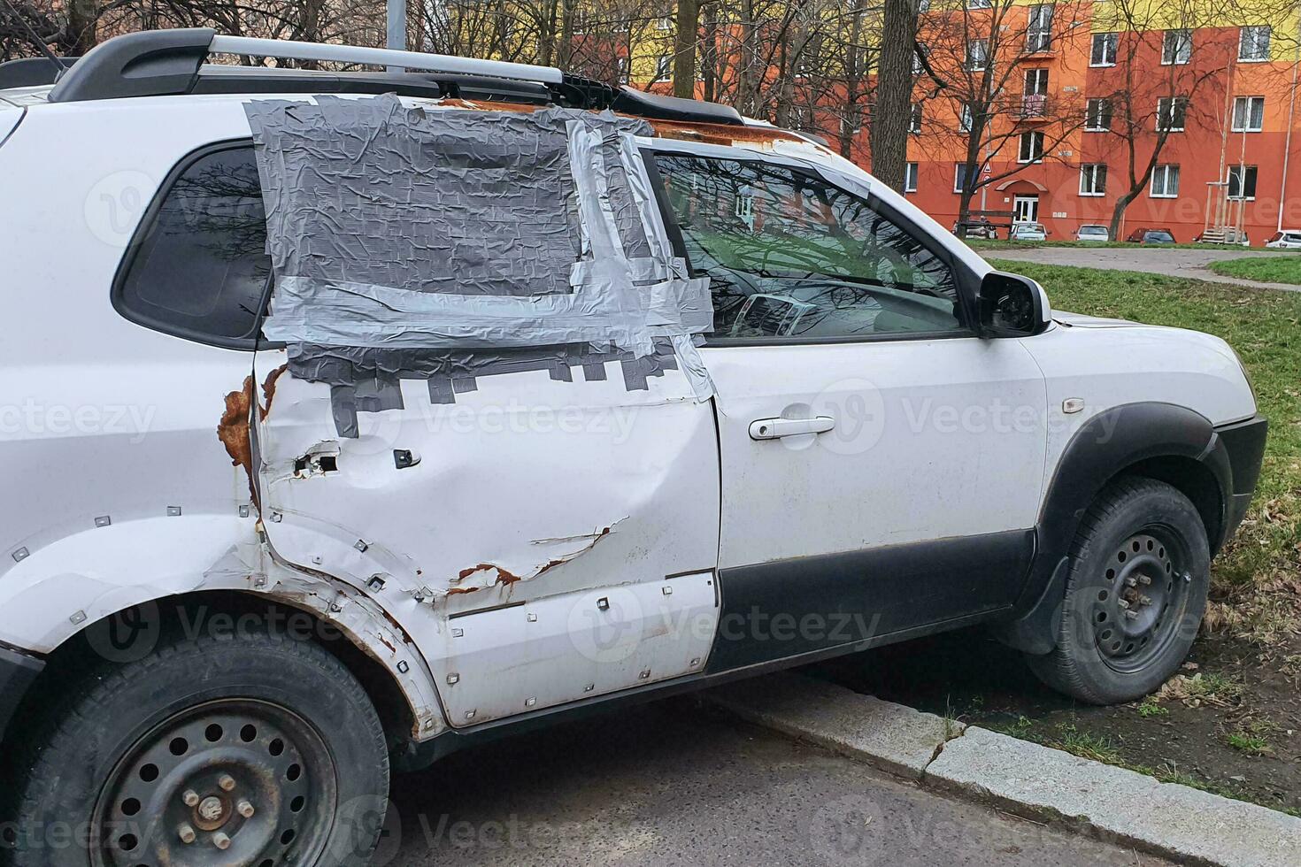 Old car with broken rear door and sealed window photo