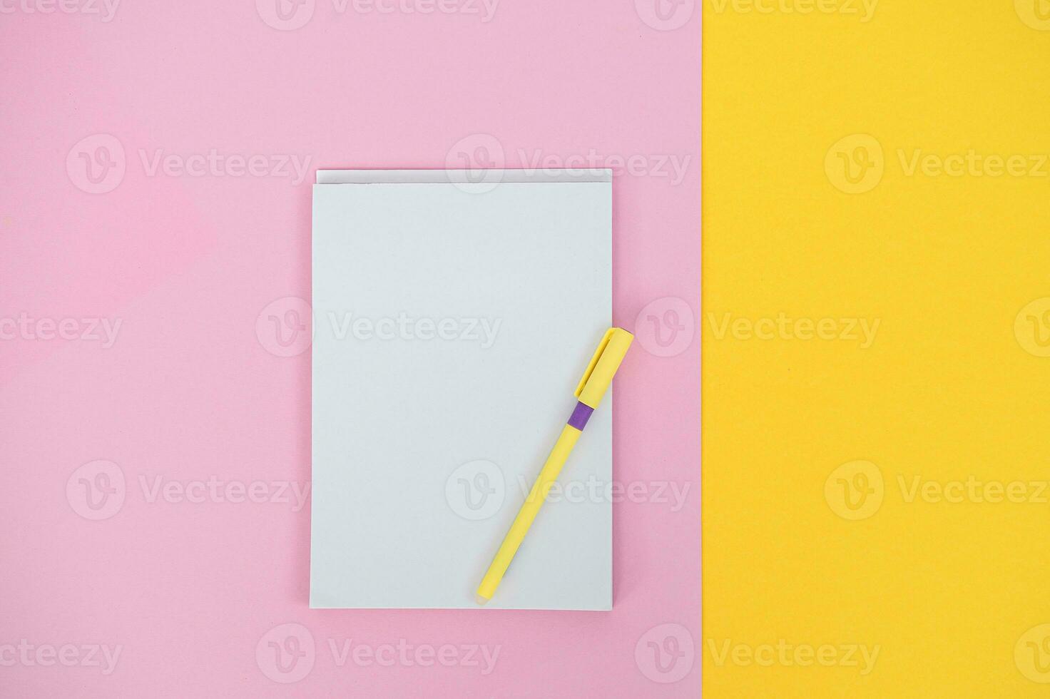 A notebook for writing on a colored background with a pen. Copy space photo