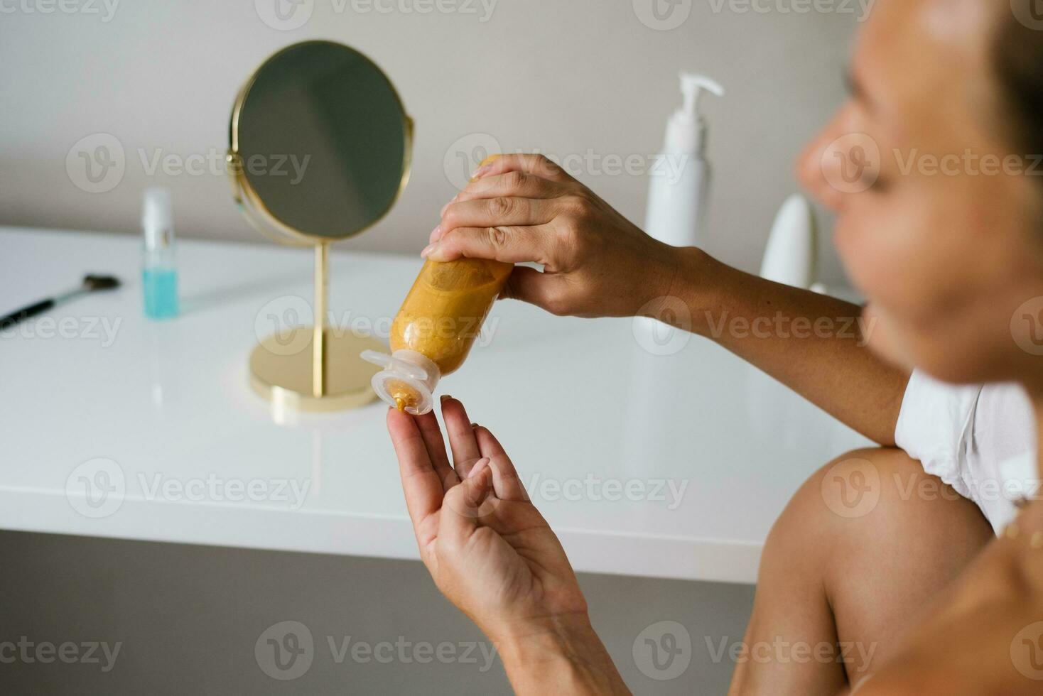 Woman applies a cosmetic moisturizer for skin care photo