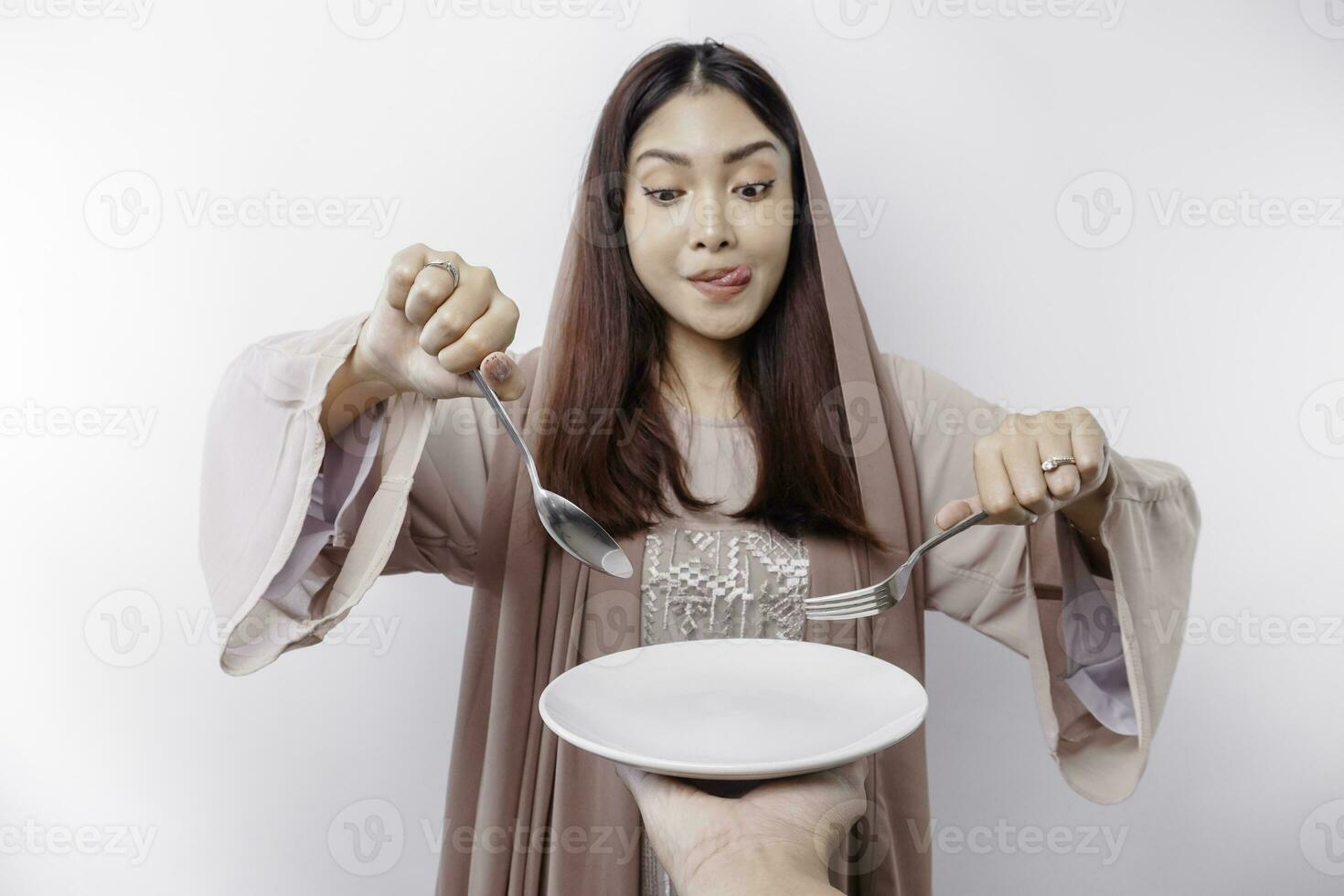 un sonriente asiático musulmán mujer es rápido y hambriento y participación y señalando a un plato foto