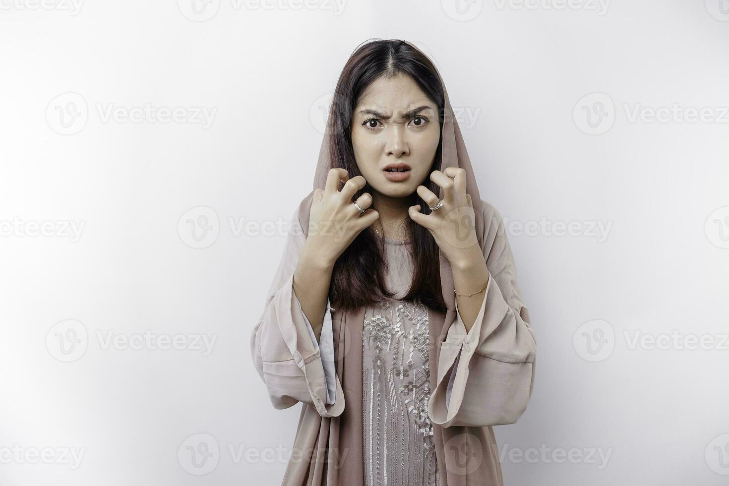 un retrato de un asiático musulmán mujer vistiendo un Pañuelo aislado por blanco antecedentes mira Deprimido foto