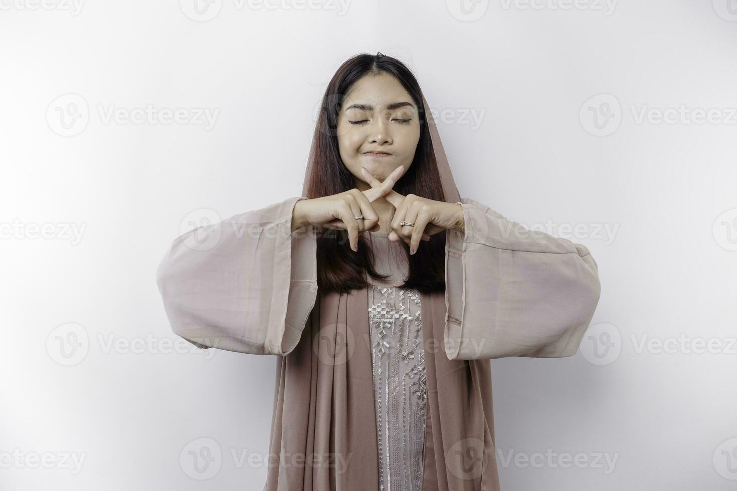Beautiful Asian Muslim woman wearing a hijab with hand gesture pose rejection or prohibition with copy space photo