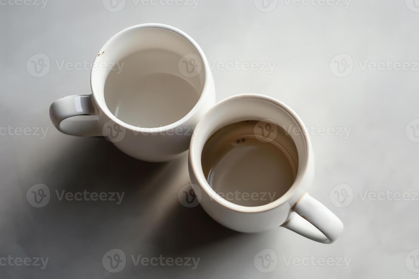 A top down look at two coffee mugs on a white background. photo