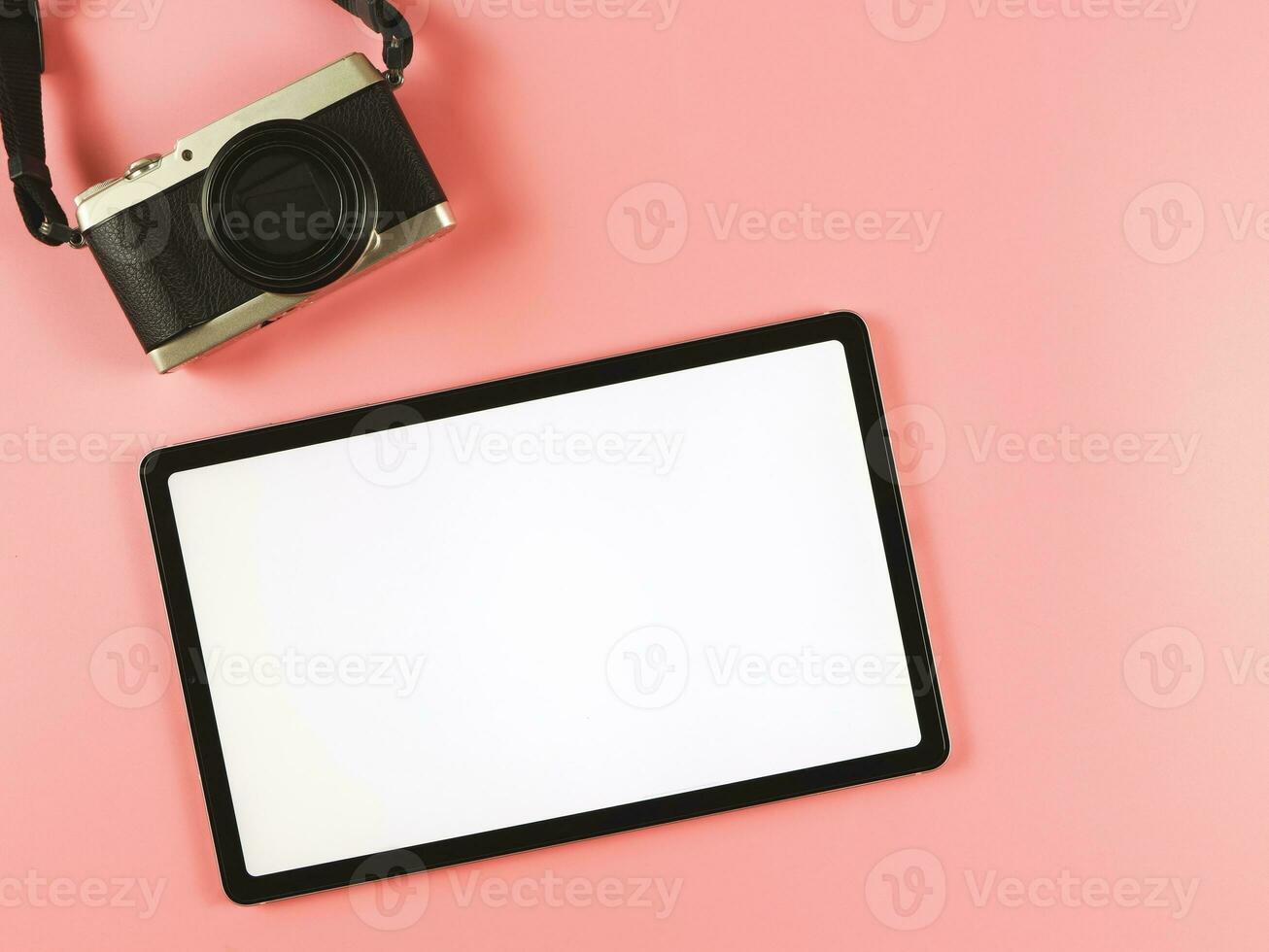 flat lay of digital tablet with blank white screen and digital camera isolated on pink background. photo