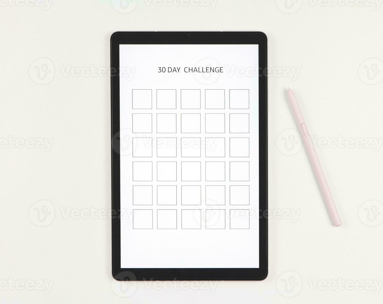 flat lay of digital tablet with template 30 day challenge on screen,  pink stylus pen,   isolated on white background. photo