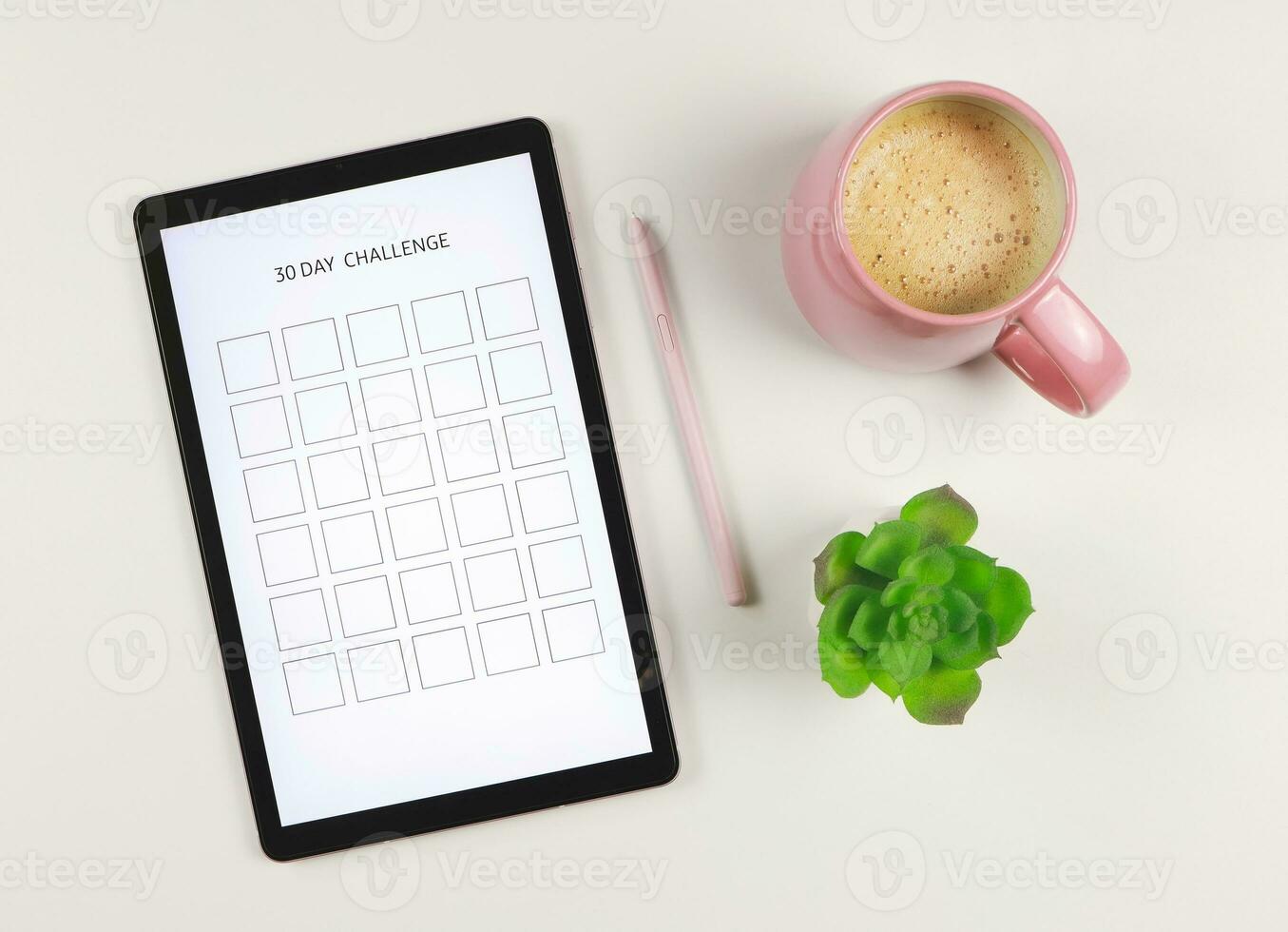 flat lay of digital tablet with template 30 day challenge on screen,  pink stylus pen, coffee and succulent plant pot  isolated on white background. photo