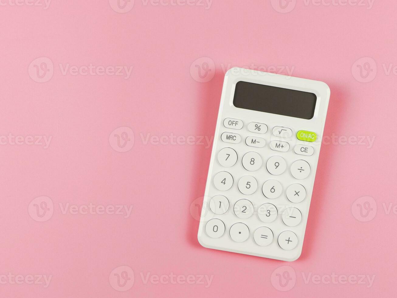 flat lay of white calculator on pink background with copy space. photo