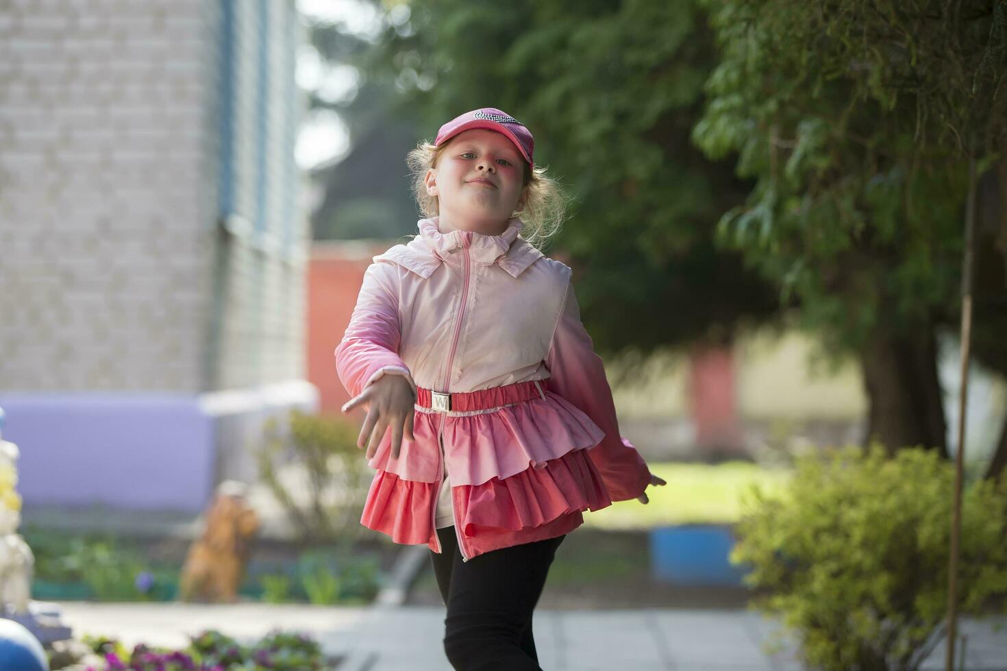 Cheerful preschool girl runs along the path. photo