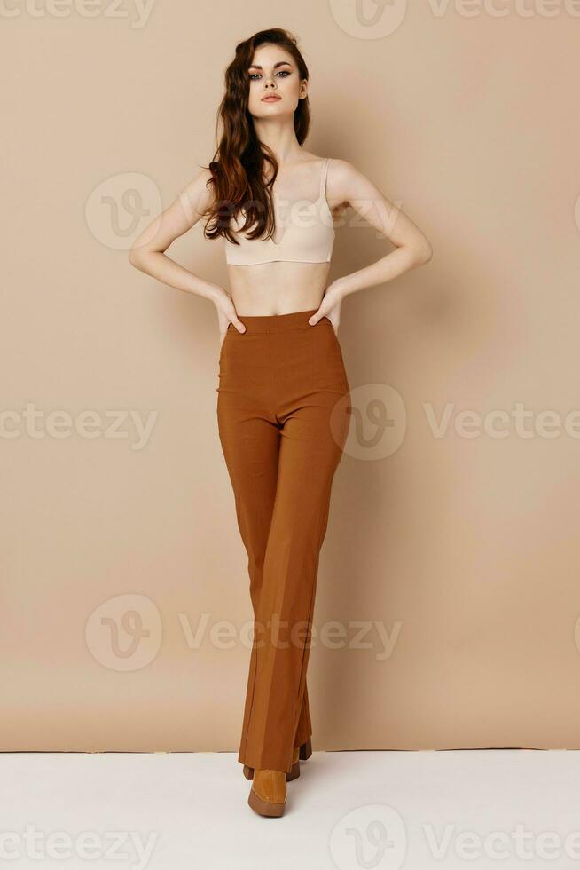 skinny woman in pants and bra boots waist hairstyle photo