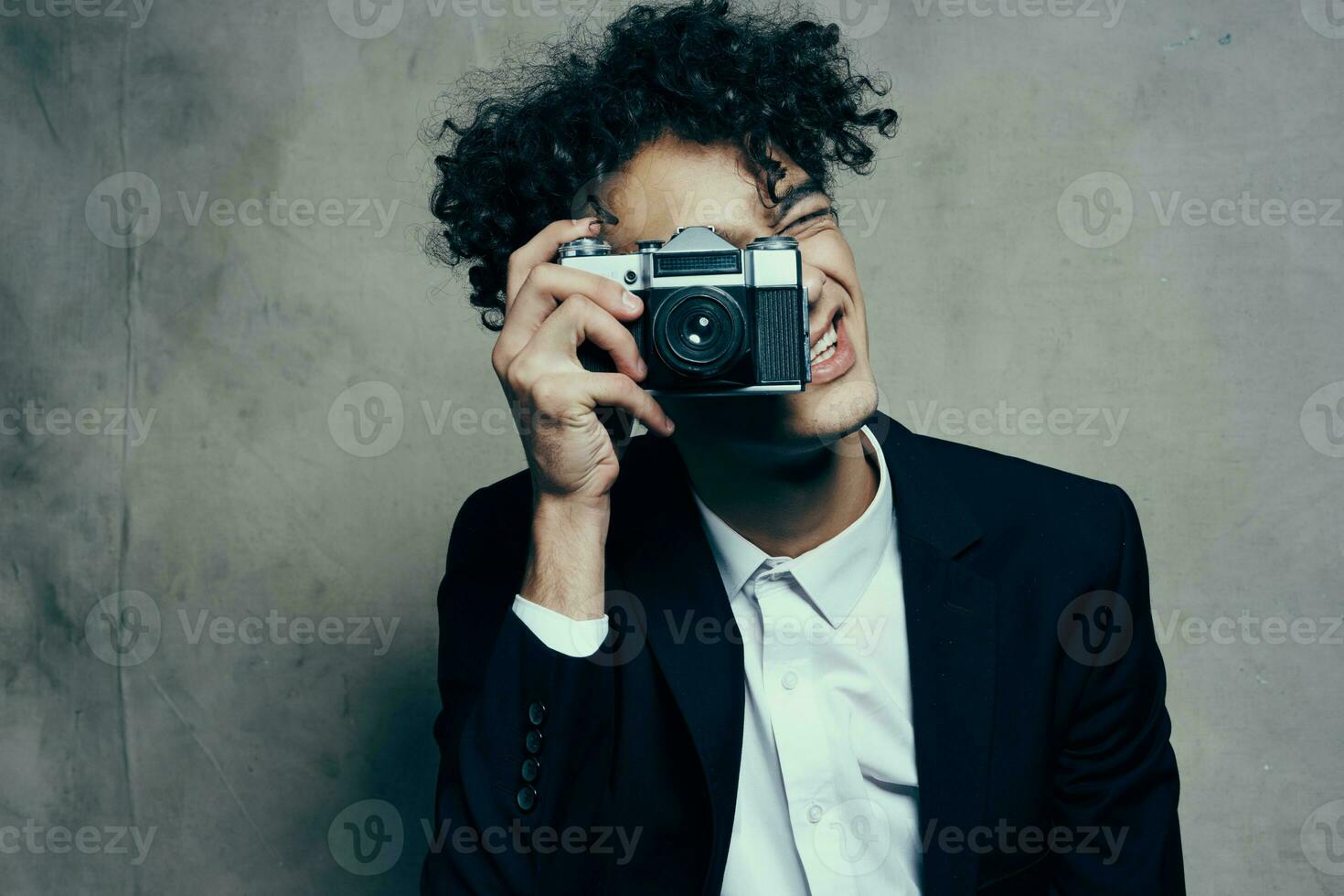 photographer with a camera in a classic suit curly hair Studio Model photo